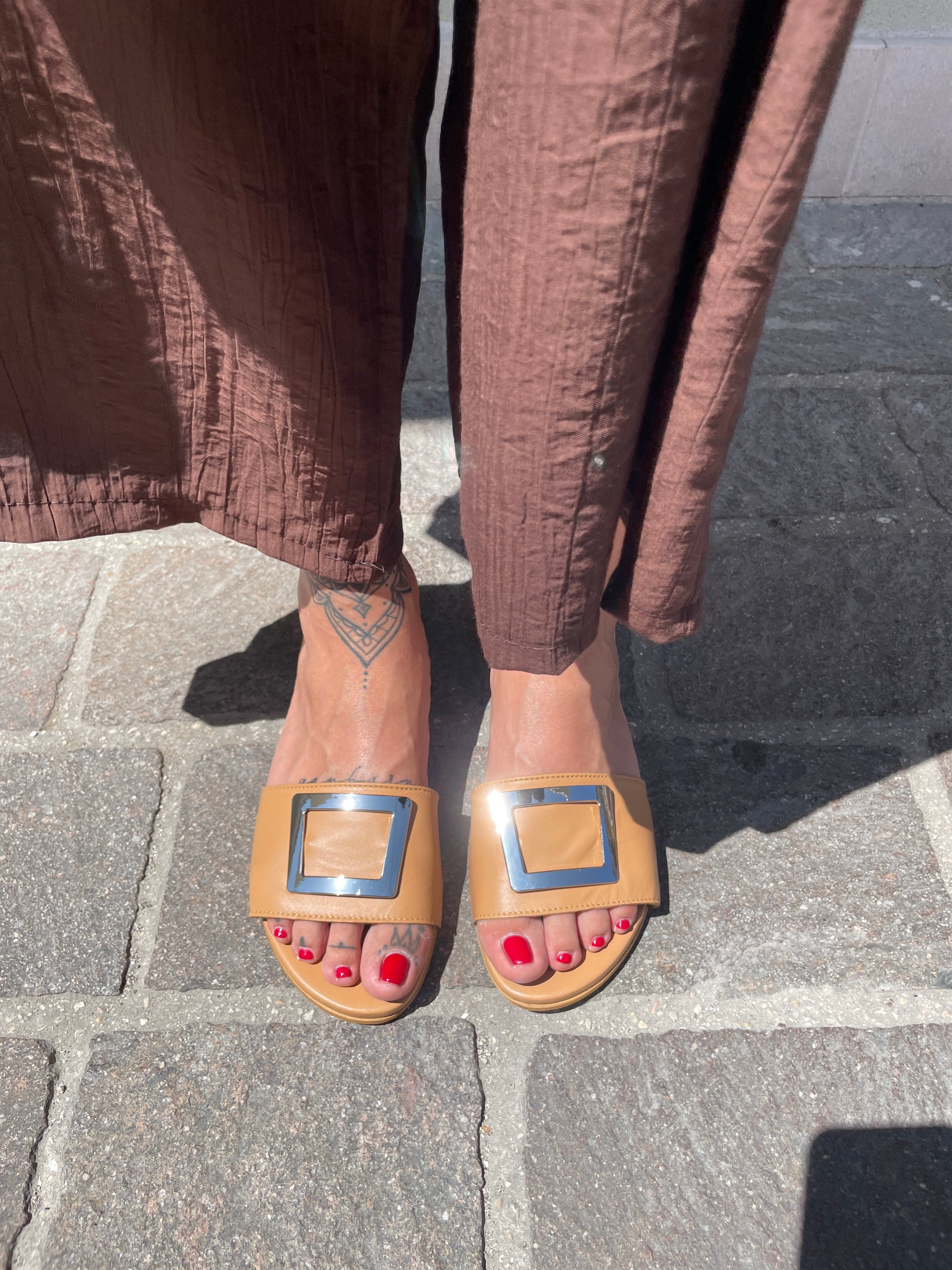 Ciabattine Guinda nappa caramello indossate vista dall alto su entrambi i piedi