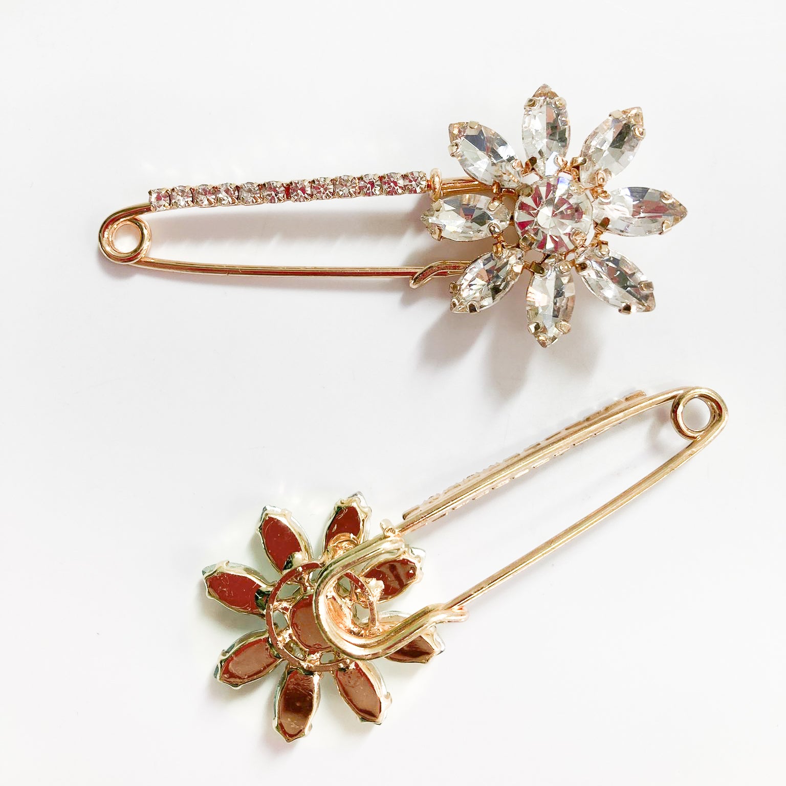 Vista a coppia con dettaglio sotto Spilla Fiore dorata con strass